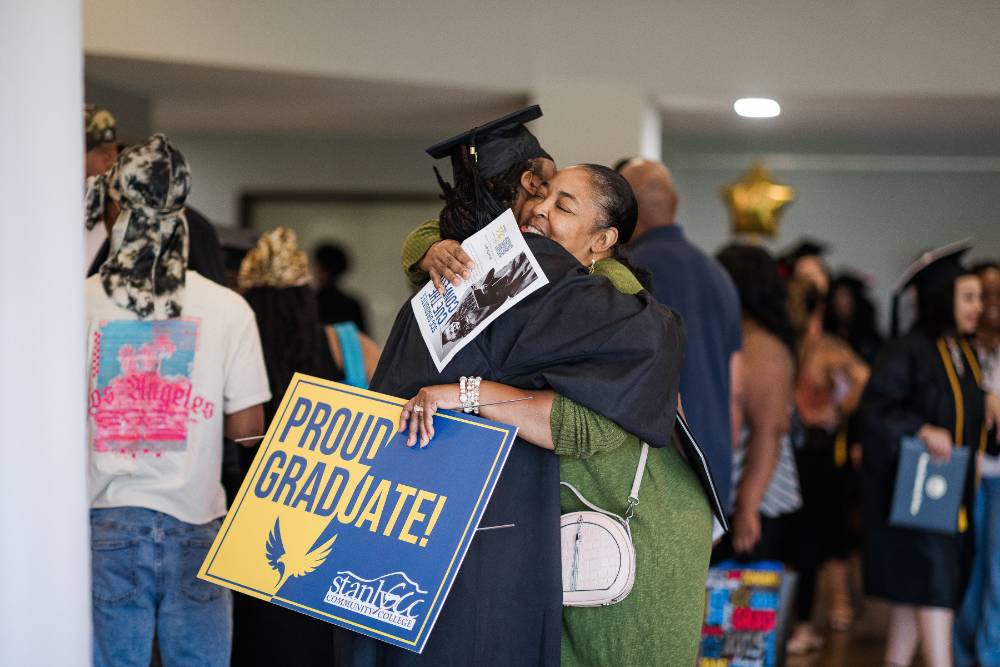 Graduate smiling and hugging