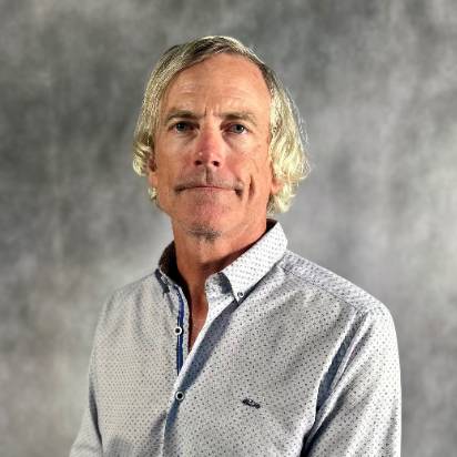 Male with blonde hair and light blue shirt with polka dots