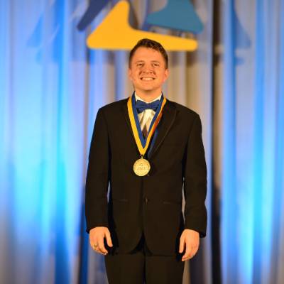 Male Student in Tuxedo with Medal Around Neck