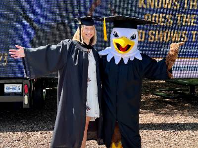 Female graduate with SCC mascot