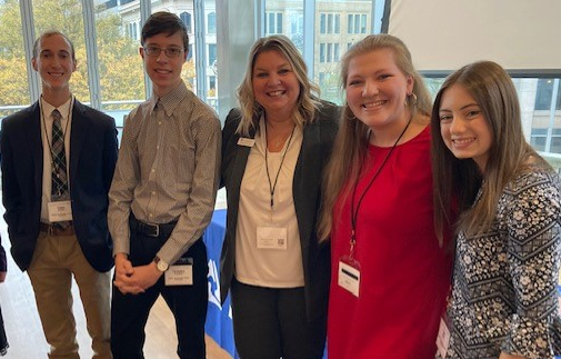 4 students standing with First Citizens Bank Employee