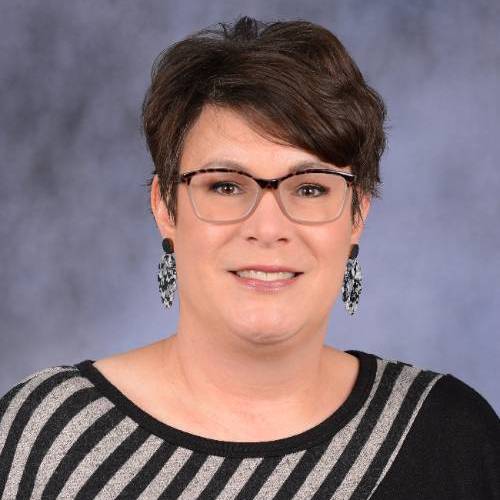 Female with dark brown short hair wearing glasses and a black and grey sweater