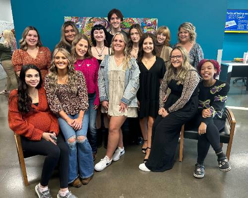 14 cosmetology students posed for picture after graduating from the program