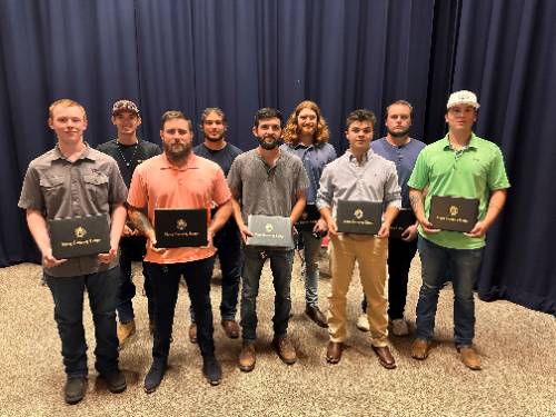 9 male graduates of SCC's electrical lineworker program.