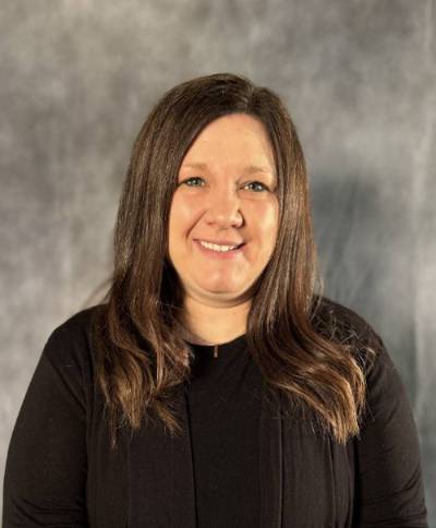 Female with long brown hair wearing black shirt smiling