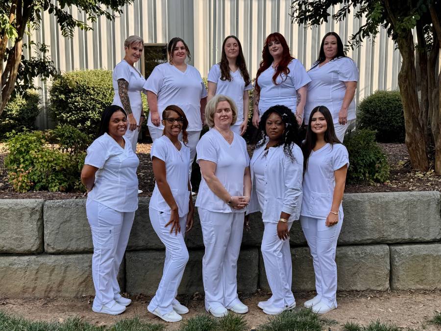ten females in white scrubs 