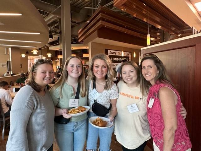 Four female students and SCC advisor in college cafeteria
